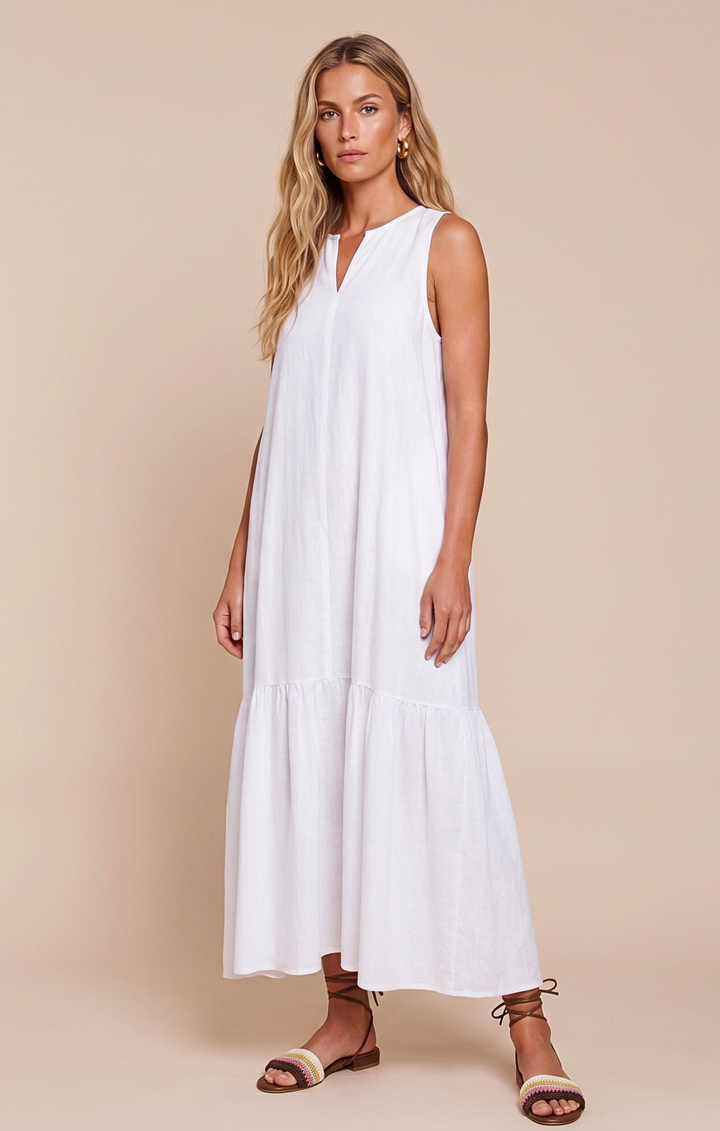 Woman wearing a white sleeveless dress against a beige background