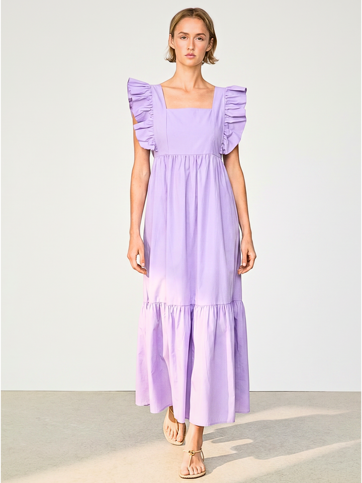 A woman modeling a lavender midi dress with ruffled cap sleeves, a square neckline, and a tiered skirt, set against a plain light gray studio background.