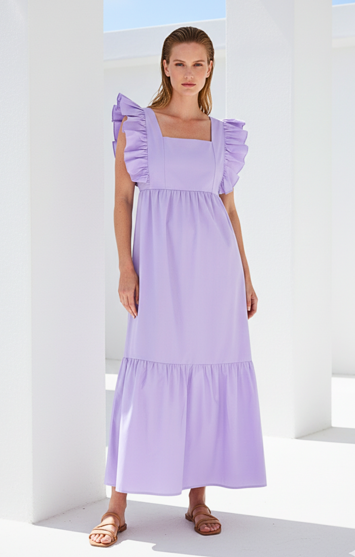 Woman wearing a lavender dress with ruffled sleeves against a white background