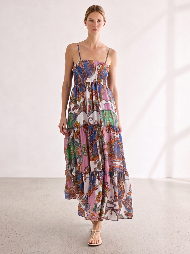 Woman wearing a colorful patterned dress against a neutral backgroun