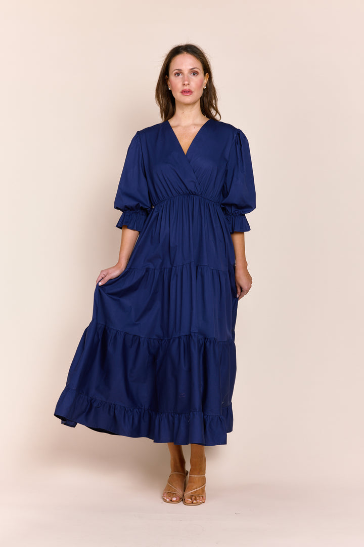 Woman wearing a blue dress against a beige background