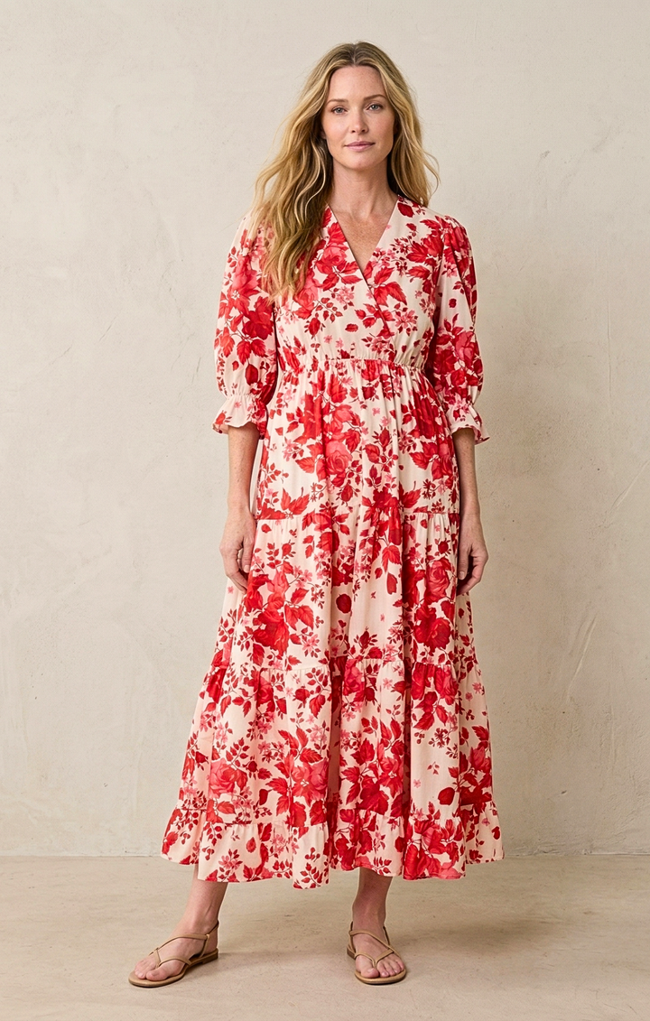 Woman wearing a red and white floral dress against a beige background