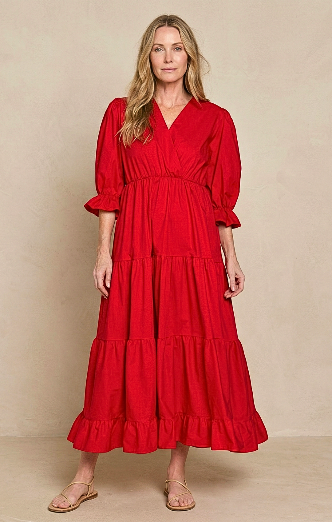 Woman wearing a red dress against a beige background