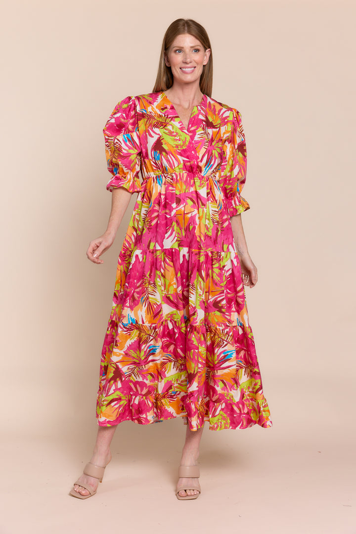 A woman modeling a red and white floral dress with 3/4 sleeves and a V-neck.