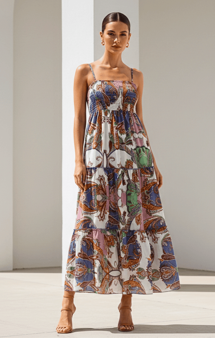 Woman wearing a colorful patterned dress against a neutral background