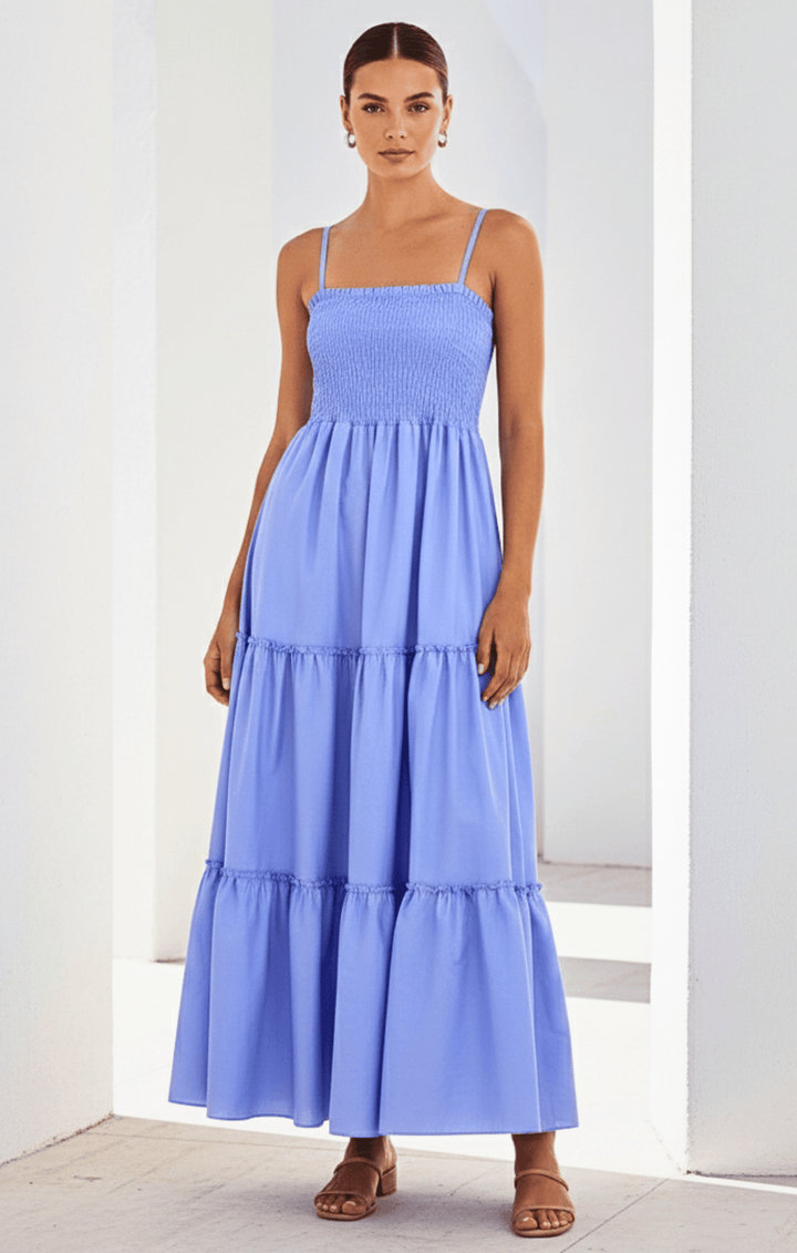 Woman wearing a light blue tiered dress against a white background