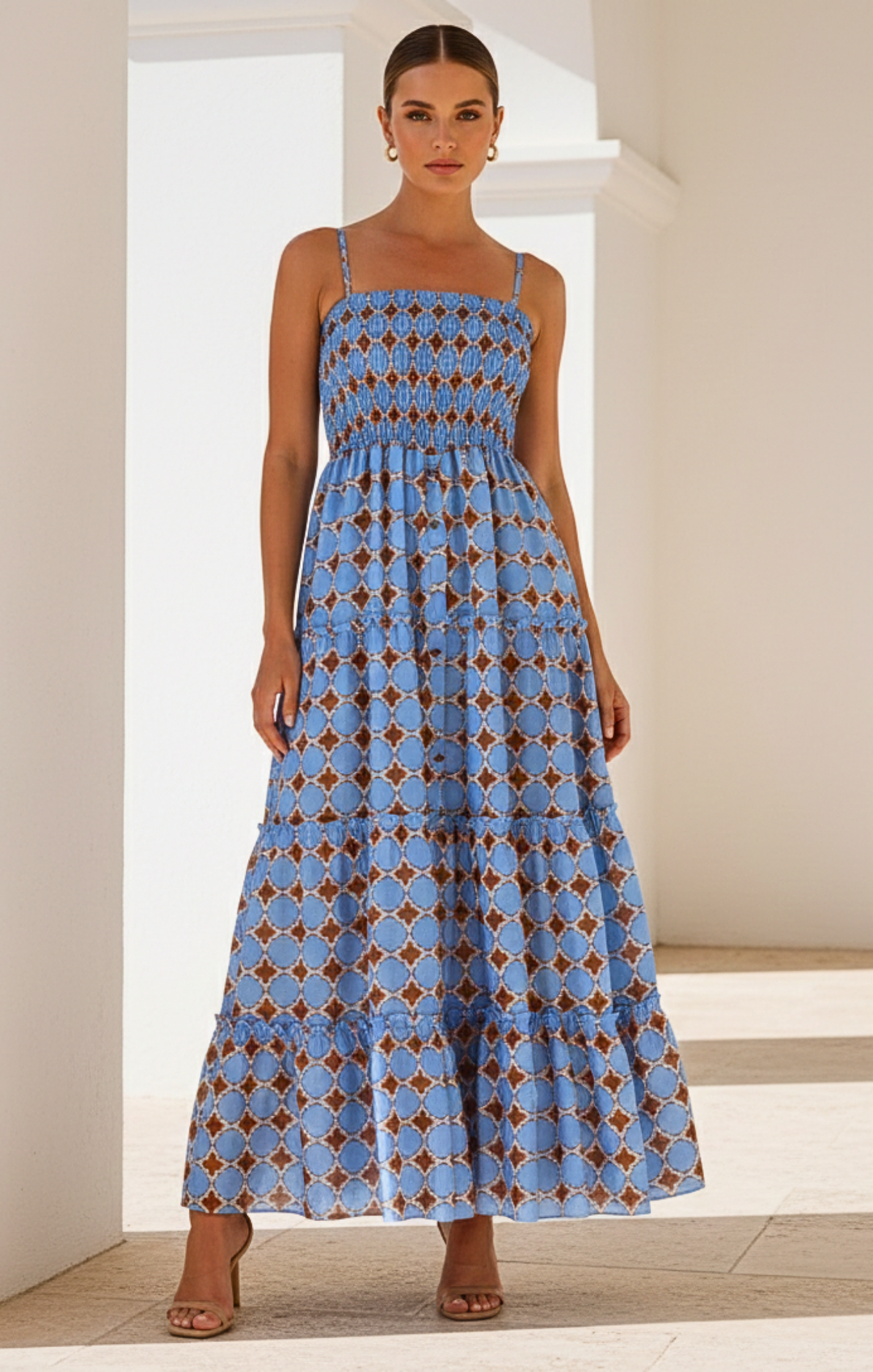Woman wearing a blue patterned dress in a bright room