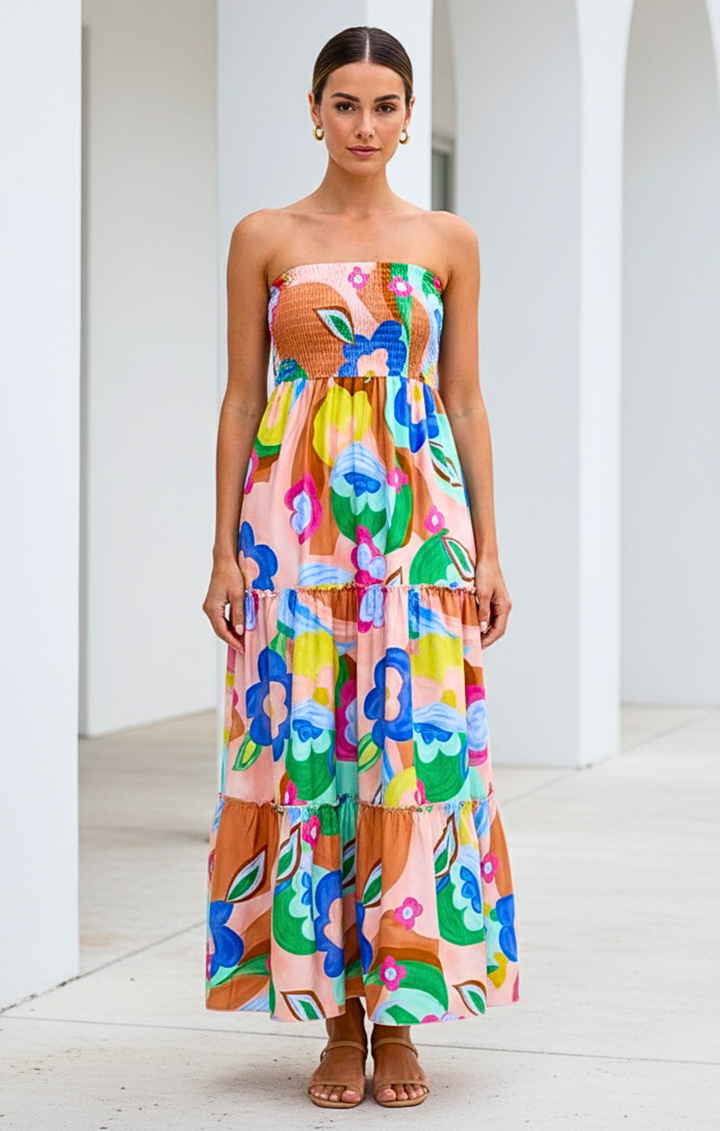 Woman wearing a colorful strapless dress with floral pattern in an indoor setting