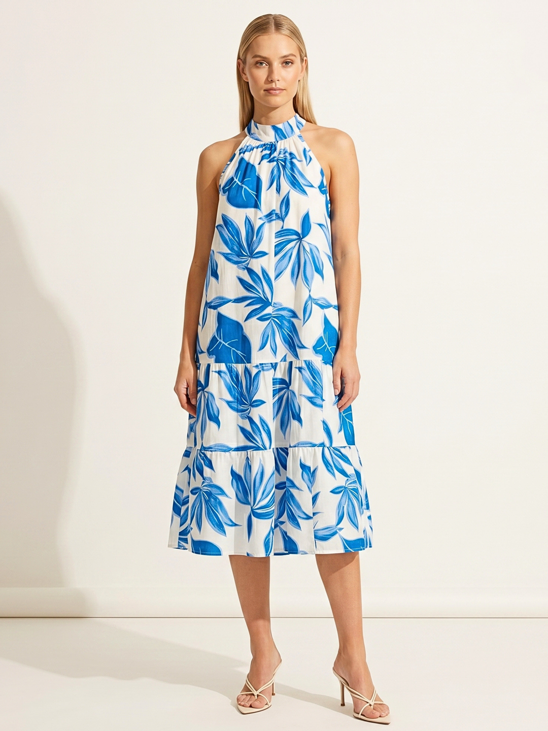 Woman wearing a blue and white floral dress on a white background