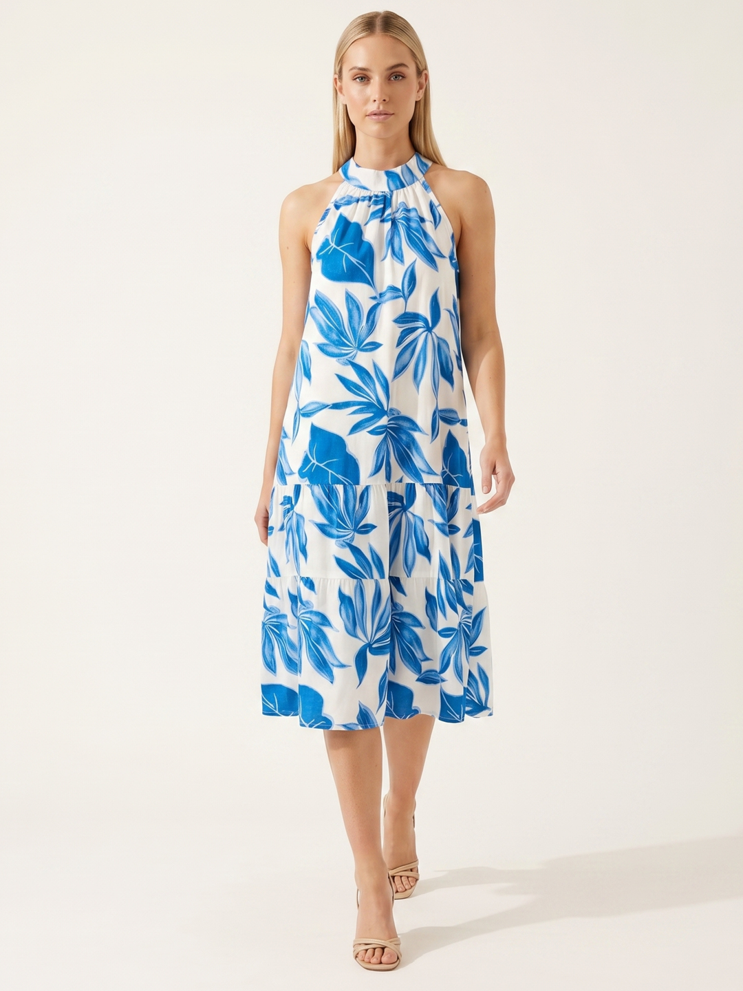 Woman wearing a blue and white floral dress on a white background