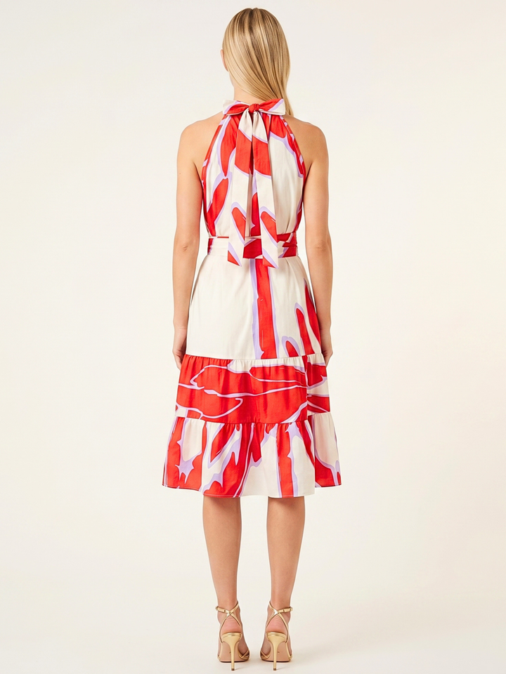 Woman wearing a red and white patterned dress on a white background