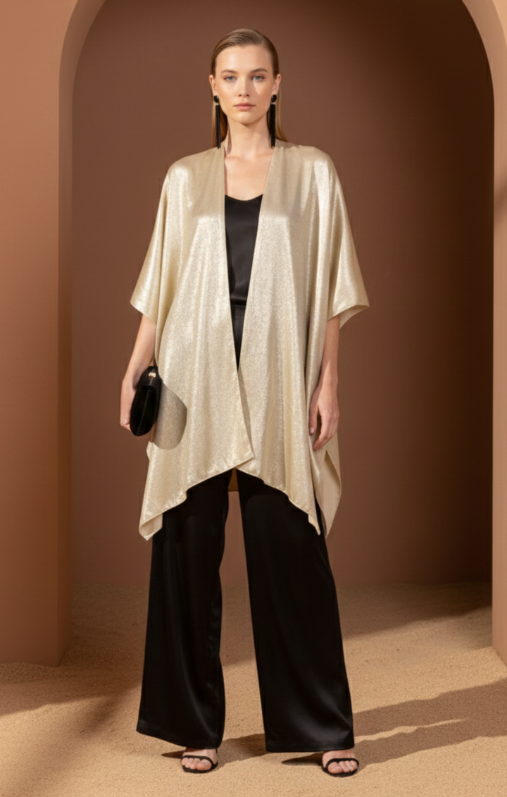 Metallic gold kimono jacket with an open front and asymmetrical hem, styled over a black silk camisole and wide-leg trousers.