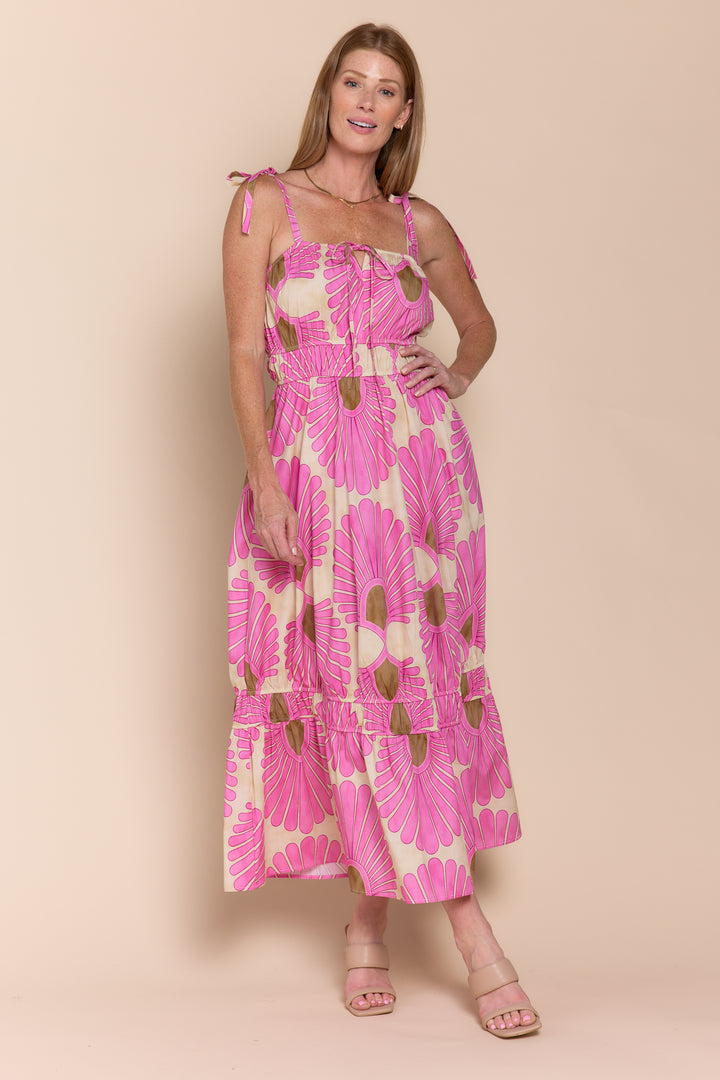 A model wearing a pink floral print sleeveless maxi dress with a square neckline and tie straps.