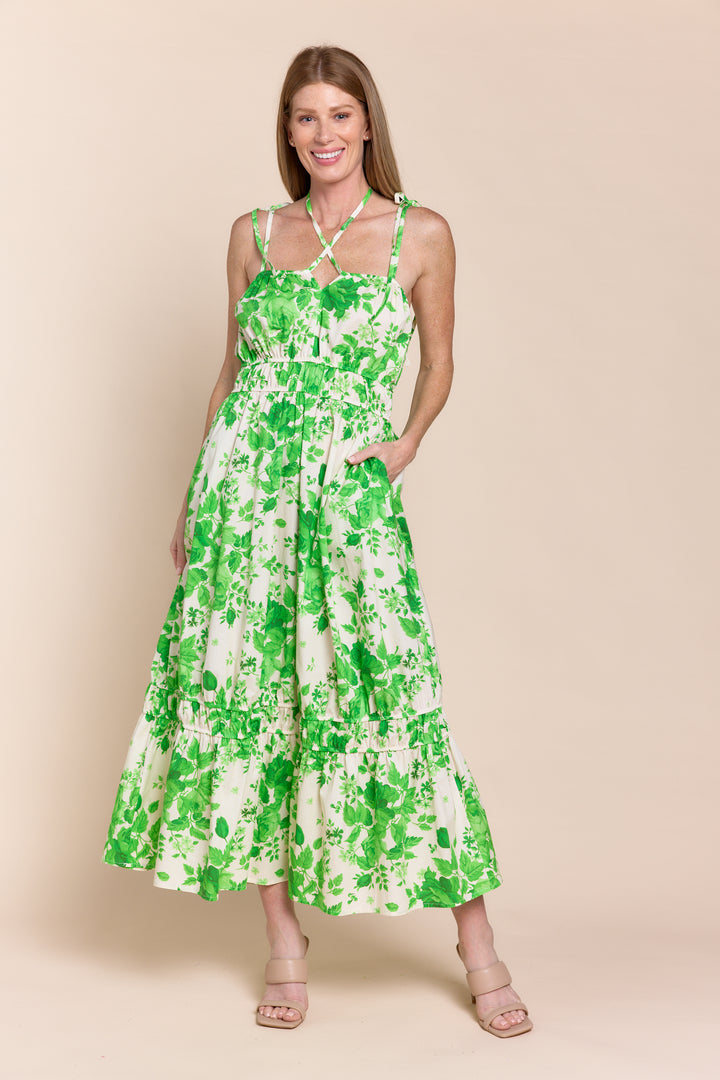 Woman wearing a green floral dress against a beige background