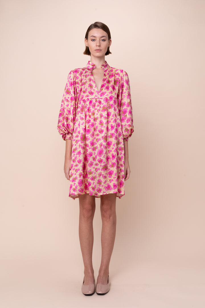 A model wearing a purple floral dress with long sleeves and a round neckline.
