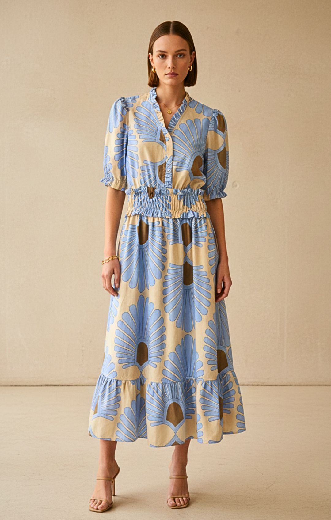 Woman wearing a blue and yellow patterned dress against a beige background