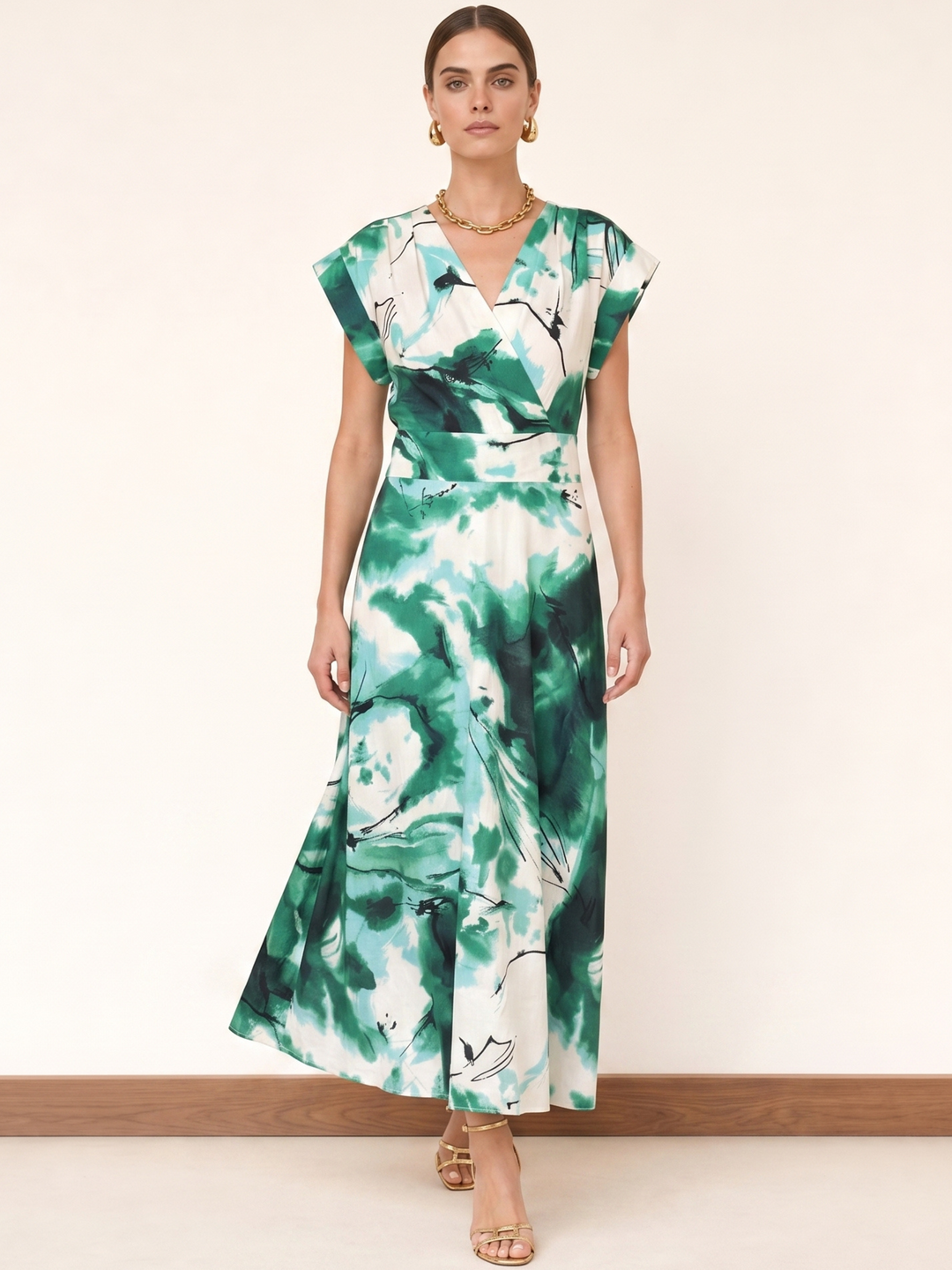 Woman wearing a green and white floral dress against a plain background