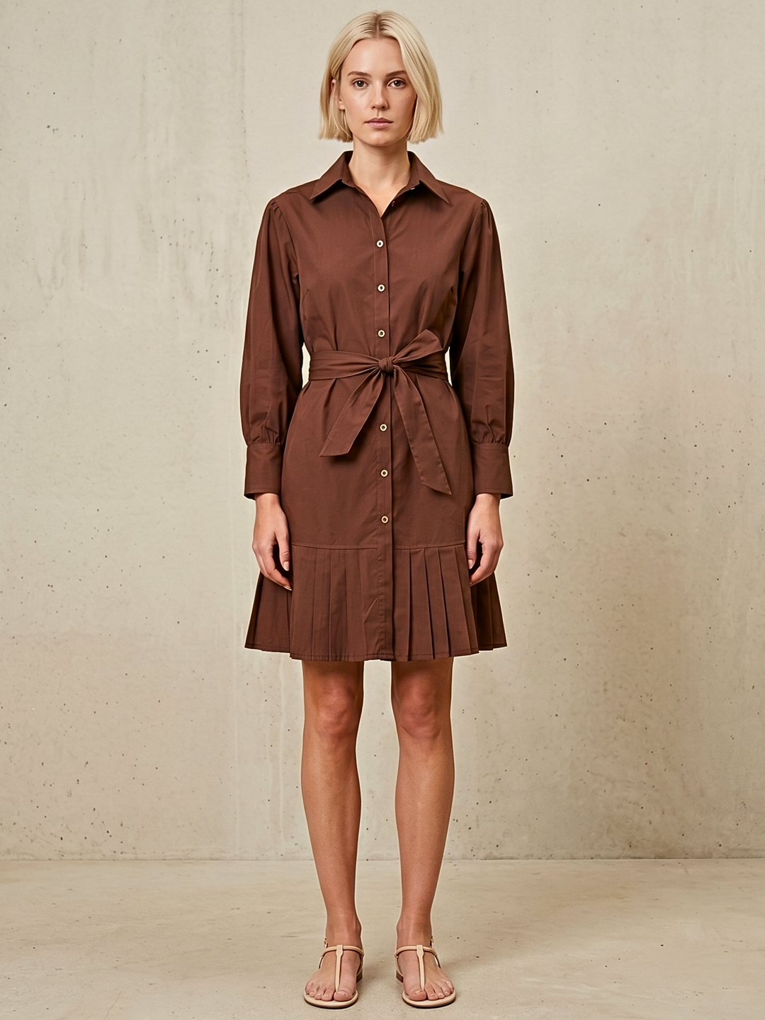 Woman wearing a brown dress against a beige background