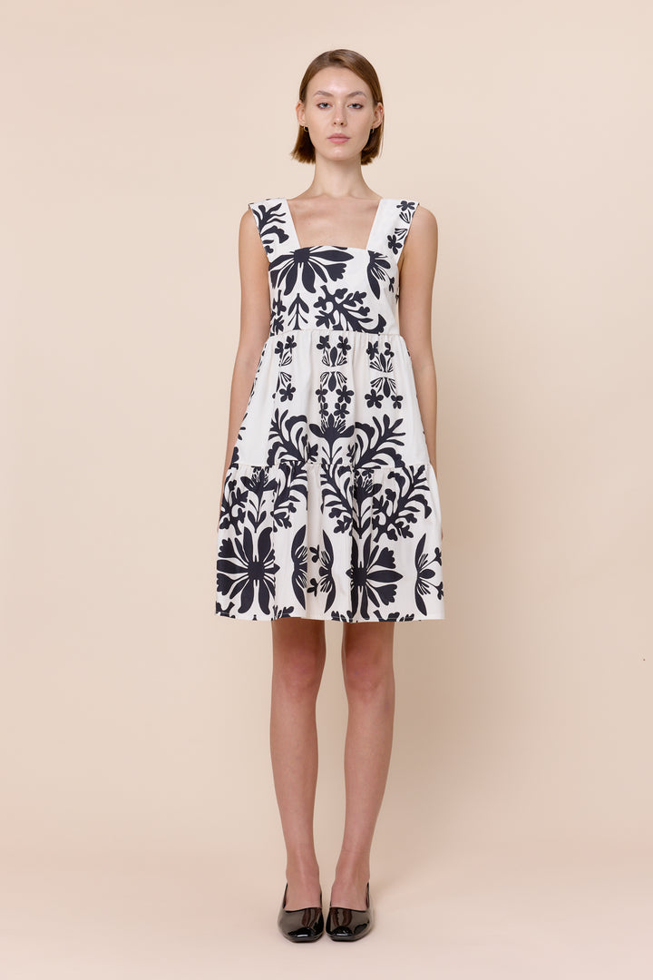 A sleeveless, mini beige and white striped dress with a square neckline and tiered skirt.