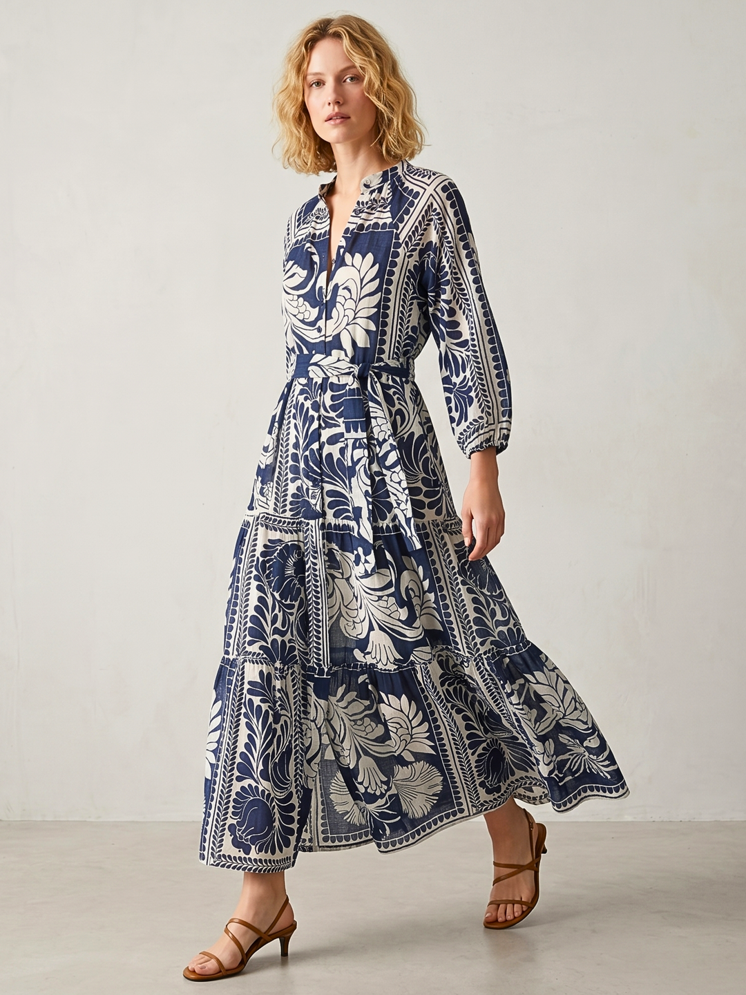 Woman wearing a blue and white patterned dress on a plain background