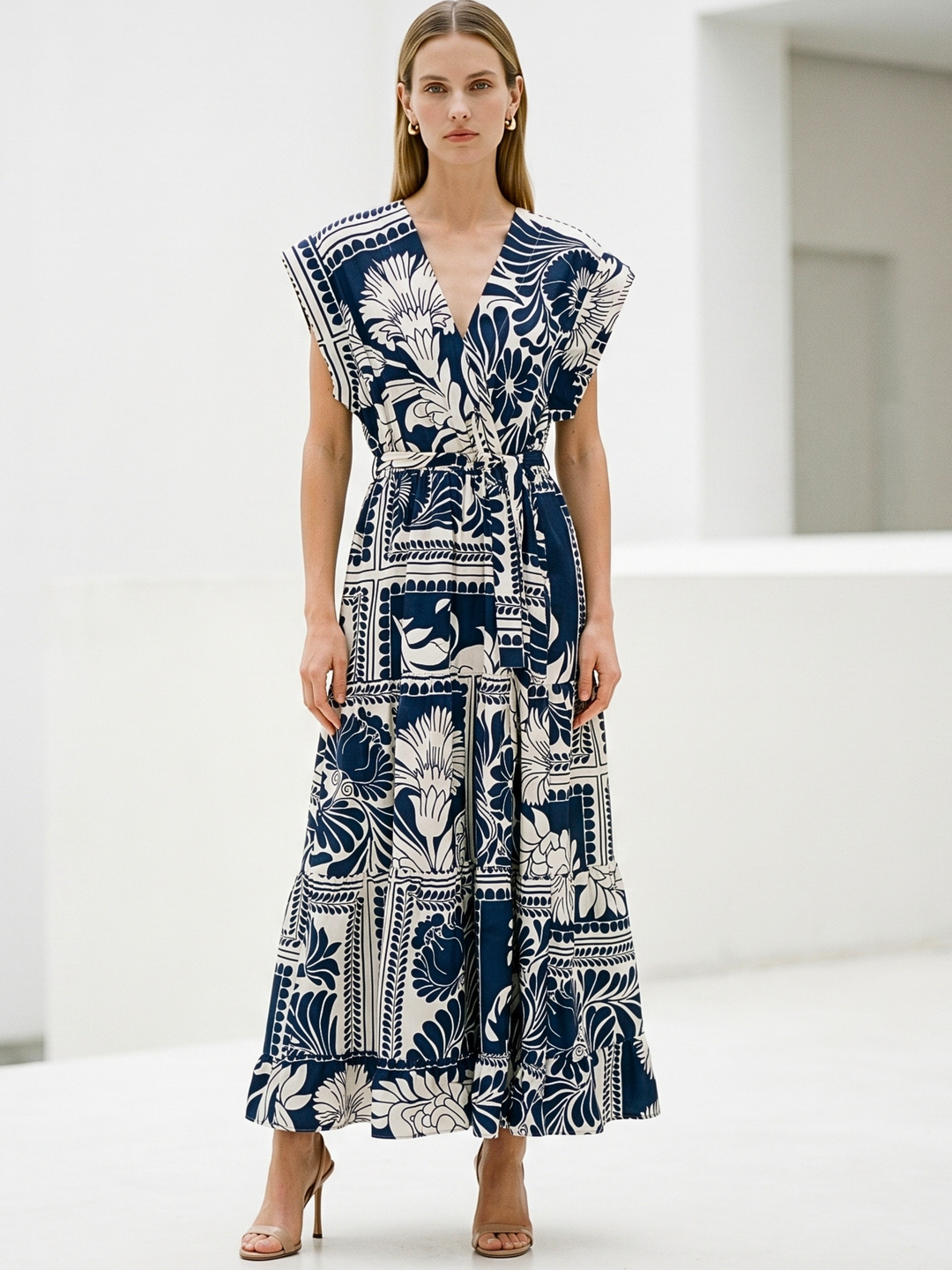 Woman wearing a blue and white patterned dress in a minimalistic setting