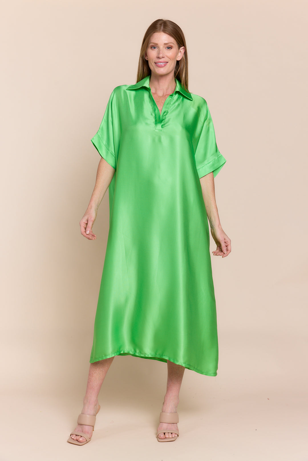 A woman wearing a green satin midi dress with short sleeves and a collar, size 2-10.