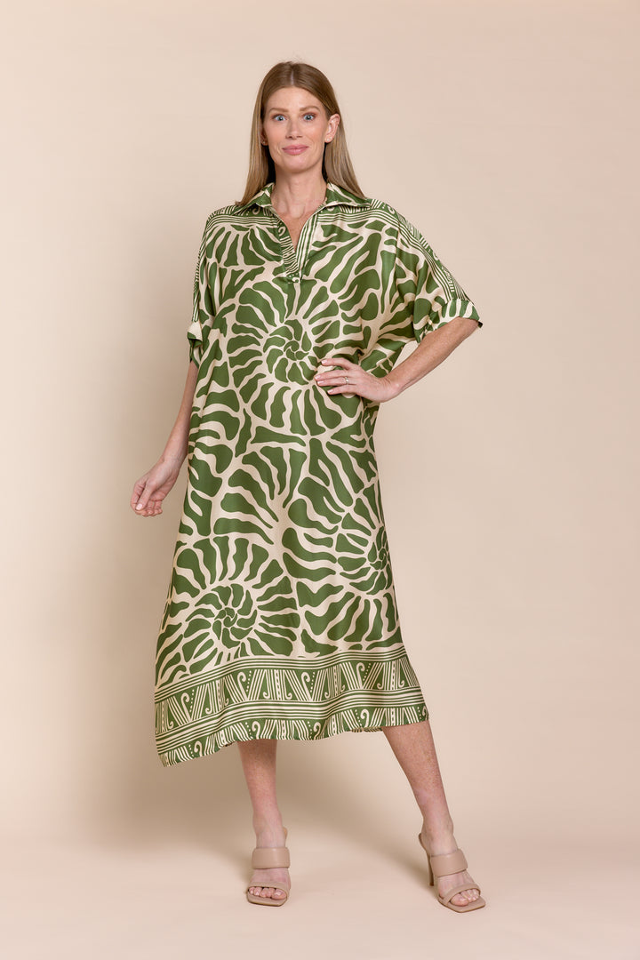 Woman wearing a green patterned dress on a beige background