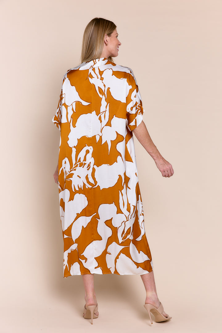 Woman wearing a floral dress with orange and white pattern on a beige background